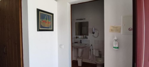 Bathroom hallway at Monte Da Morena Agro-Turismo in Serpa with sink, mirror, and hand sanitizer dispenser