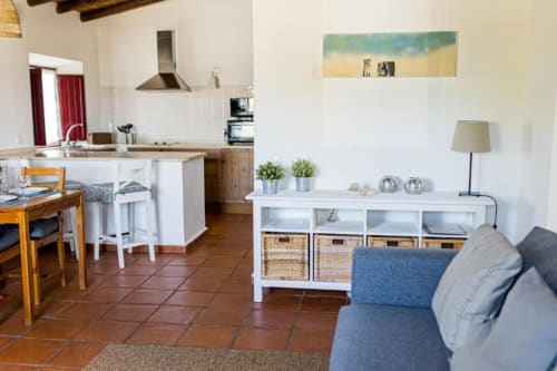 Open-plan living and kitchen area in 2-bedroom apartment at Monte Da Morena, Serpa with terracotta floors, white cabinetry,