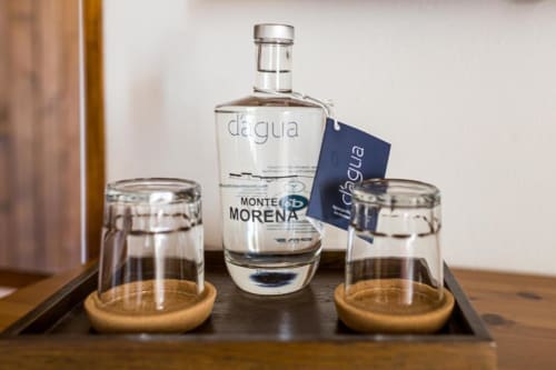 Monte Da Morena agua de drinking water bottle with two glasses on wooden coasters at Serpa guesthouse