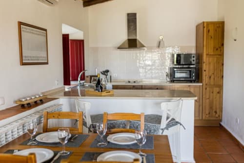 Open-plan kitchen and dining area in Monte Da Morena's 2-bedroom apartment, Serpa, Portugal, with dining table, wooden