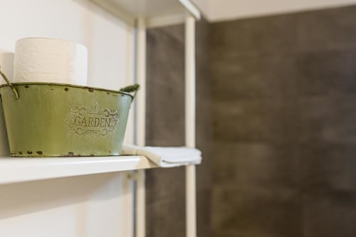 Green garden-themed tissue holder with roll on shelf at Monte Da Morena, Serpa