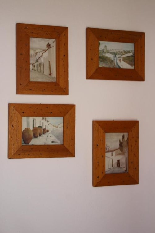 Four framed architectural prints with wooden frames hung on white wall at Monte Da Morena, Serpa