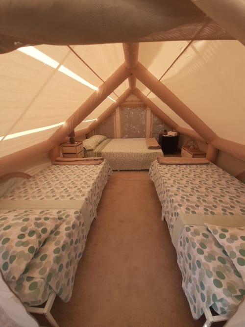 Intérieur de tente glamping au Baia Dorica Camping Village, Vittoria avec lits jumeaux et structure en bois