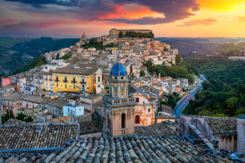 Modica, ville perchée au coucher de soleil en Sicile, Italie avec ses bâtiments colorés et son église à dôme bleu