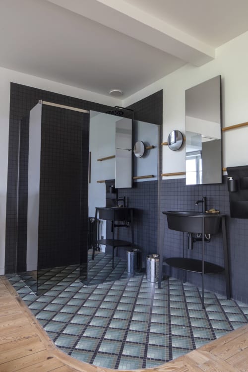 Salle de bains moderne de la Villa Sonneville à Roubaix : carrelage noir, double vasque, douche à l'italienne et accents bois