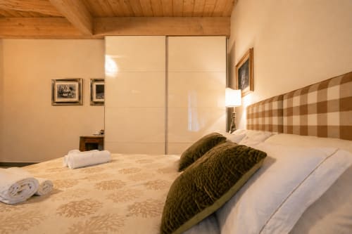 Camera di lusso all'Al Battistero di Ravenna con letto king, testata a quadri, armadio moderno e vista sulla città