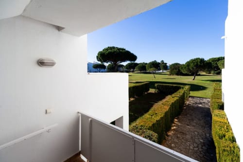 Vista del balcón del Apartamento Retama en Barrosa Home, con vistas a jardines cuidados y campos de golf en España