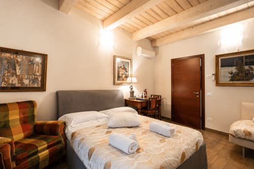 Ampia camera tripla con vista sulla città presso Al Battistero Luxury Suite, Ravenna, con travi in legno a vista e aria condizionata