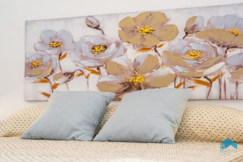 Dormitorio de la Villa Granizo en Barrosa Home con almohadas azules y obra floral con flores blancas y doradas sobre la cama