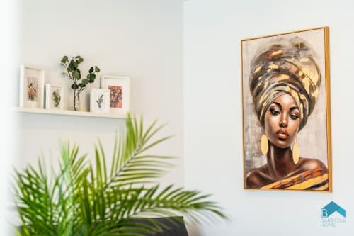 Decoración moderna en Barrosa Home con cuadro de retrato, estante flotante con plantas botánicas y maceta