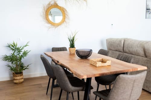 Área de comedor Villa Bison en Barrosa Home con mesa de madera, sillas grises, plantas en maceta y espejo