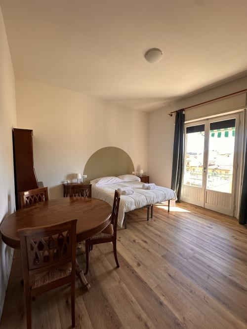 Spaziosa camera d'hotel a Firenze con letto, arredamento in legno e balcone con vista sulle strade della città presso Funari Tuscany Stays