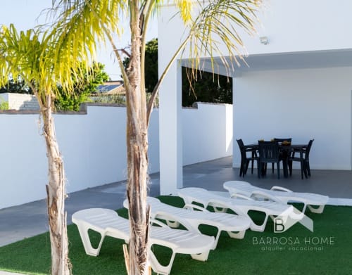 Villa Barrosa con tumbonas blancas, palmeras y arquitectura moderna en España