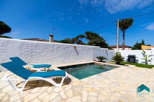 Villa Barrosa con piscina privada, tumbonas azules, cerca blanca y patio en España