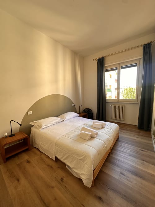 Camera da letto luminosa presso Funari Tuscany Stays a Firenze con letto matrimoniale, comodino in legno e vista finestra