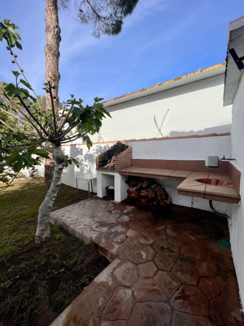 Villa Barrosa con patio de terracota, horno de ladrillo, palmera y paredes encaladas en España
