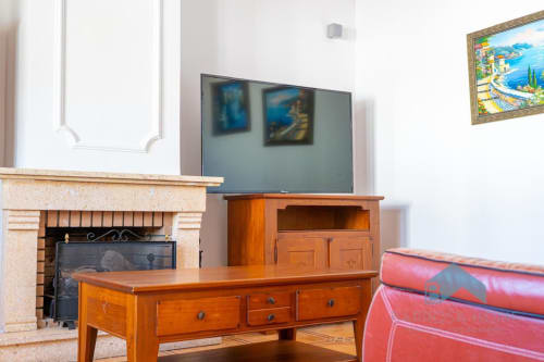Apartamento Villa Alba en Barrosa Home con muebles de madera, chimenea, TV y sofá rojo en la sala