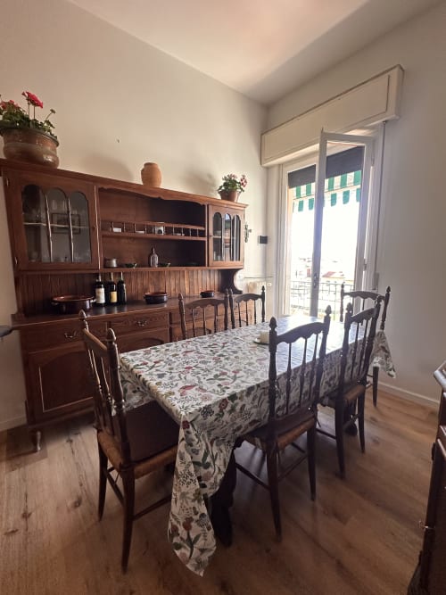 Sala da pranzo toscana con mobili in legno, tovaglia floreale e vista sul balcone presso Funari Tuscany Stays, Firenze