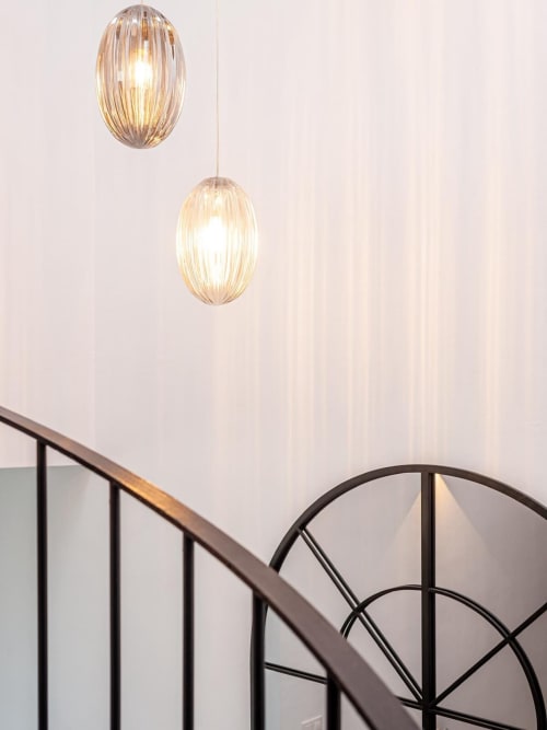 Lámparas colgantes modernas sobre escalera con barandilla metálica en apartamento Barrosa Home, España