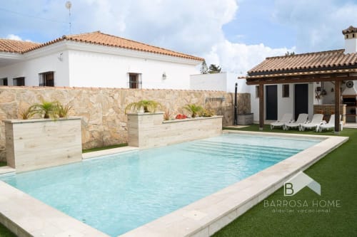 Villa Barrosa con piscina, terrazas y arquitectura española tradicional en soleado patio interior
