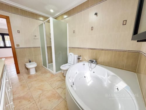 Amplio baño de la villa Barrosa Home con jacuzzi blanco, cabina de ducha, inodoro y bidé