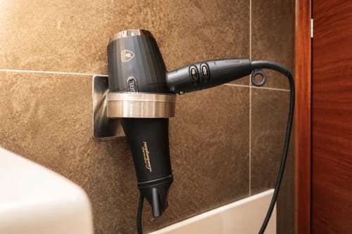 Asciugacapelli nero montato a parete nel bagno della suite di lusso Al Battistero, Ravenna