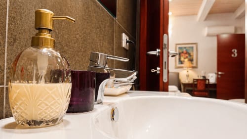 Lussuoso lavabo da bagno presso Al Battistero Suite a Ravenna con dispenser di sapone e rubinetto moderno