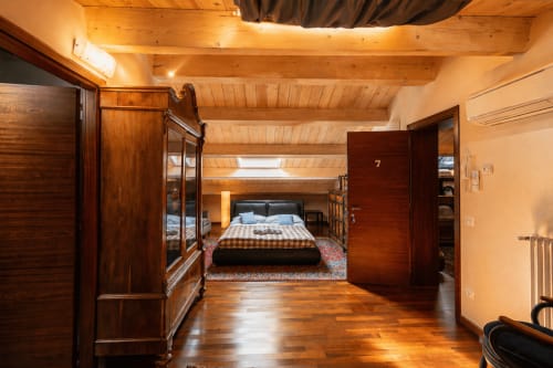 Spaziosa suite familiare ad Al Battistero a Ravenna con travi in legno, mobili in legno scuro e vista della camera da letto