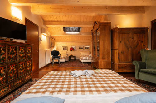 Ampia camera familiare presso Al Battistero Luxury Suite a Ravenna con travi in legno, biancheria a quadri e arredamento tradizionale