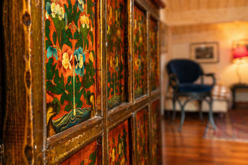 Eleganti porte in legno intarsiato con decorazioni floreali colorate presso l'Al Battistero Luxury Suite a Ravenna, Italia