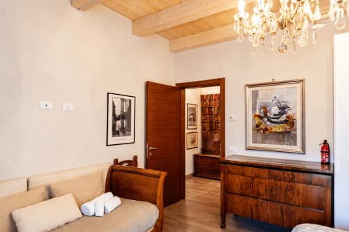 Elegante suite dell'Al Battistero con travi in legno, mobili d'epoca, opere d'arte incorniciate e lampadario a Ravenna