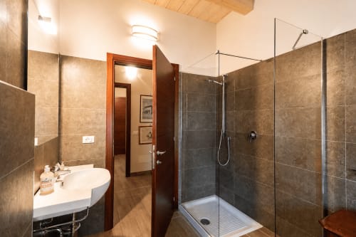 Bagno moderno nella Luxury Suite Al Battistero di Ravenna con doccia, lavabo rotondo e scaldasalviette