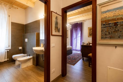 Bagno e camera da letto della Luxury Suite Al Battistero a Ravenna, Italia con arredi moderni e vista sul giardino