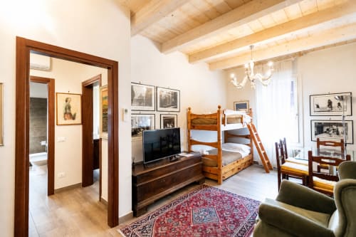 Ampia suite al Al Battistero Luxury Suite a Ravenna con letti a castello in legno, TV, accesso a angolo cottura e vista sul giardino