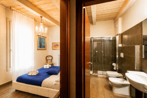 Suite moderna presso Al Battistero luxury B&B a Ravenna con camera da letto e bagno privato con doccia in piastrelle scure e legno