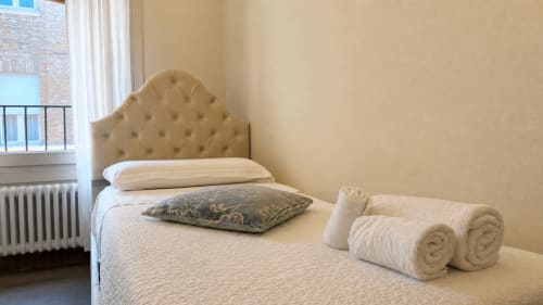 Suite elegante ad Al Battistero a Ravenna con testata trapuntata, biancheria bianca, asciugamani arrotolati e vista sulla città