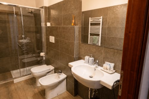 Bagno moderno nella Suite Al Battistero, Ravenna con doppio lavabo, box doccia e scaldasalviette