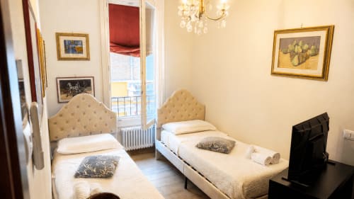 Camera doppia in Al Battistero Luxury Suite a Ravenna con testiere rivestite color crema, vista sulla città e arredamento classico