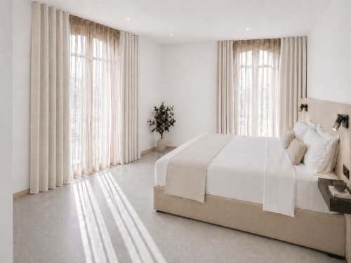 Chambre Supérieure lumineuse à l'hôtel Le Palmier à Aigues-Mortes avec rideaux crème, literie neutre et lumière naturelle