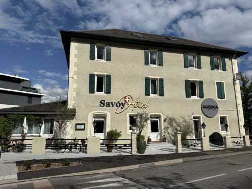 Hôtel Savoy au Bourget-du-Lac, bâtiment beige aux volets verts et toiture sombre