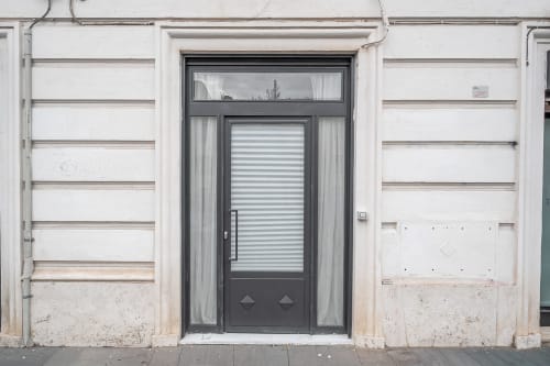 Modern dark entrance door with striped glass panel at Colosseum Exclusive Stay apartment in Rome, Italy