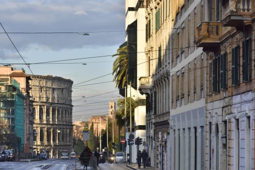 Historic Roman street with classical architecture buildings and palm trees near Colosseum Exclusive Stay apartment hotel in