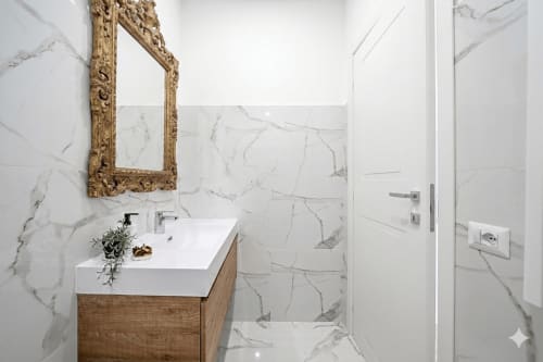 Modern bathroom with marble walls and wood vanity at Colosseum Exclusive Stay Rome apartment