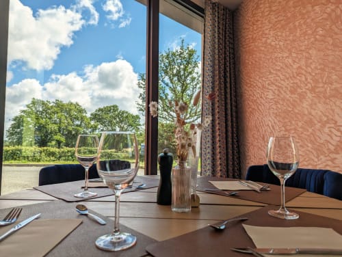 Salle à manger élégante à La Verriaire avec couverts, verres à vin et vue sur la campagne de Chanverrie