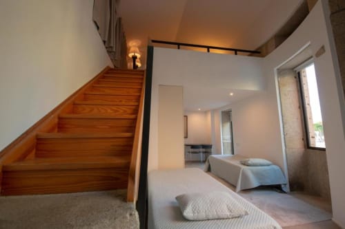 Quarto estilo loft moderno na Quinta da Malaposta, Valença com escadas em madeira, camas twin e vista para a piscina