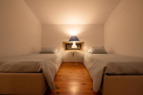 Quarto duplo no Apartamento 2 da Quinta da Malaposta, Valença com piso de madeira e iluminação acolhedora