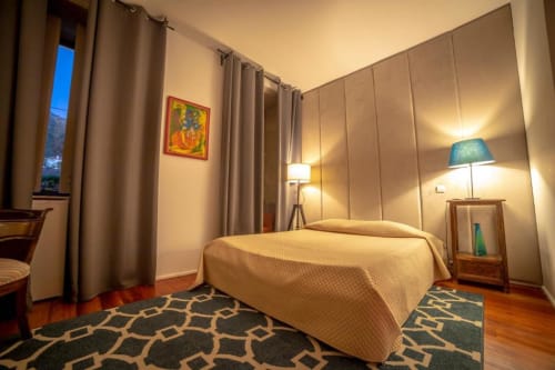 Quarto do hotel Quinta da Malaposta em Valença com cama, móveis de madeira, tapete estampado e iluminação aconchegante