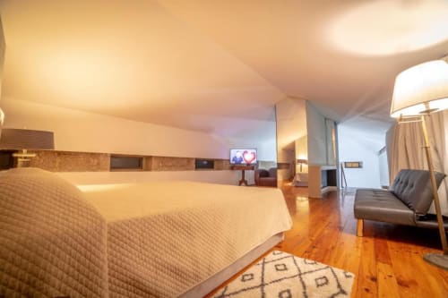 Suite Superior Familiar na Quinta da Malaposta em Valença com cama, sofá, assoalho de madeira e vista para o jardim