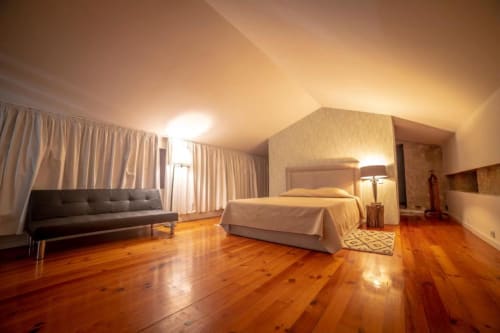 Suite Superior Familiar espaçosa na Quinta da Malaposta em Valença com piso de madeira, cama, sofá e iluminação ambiente