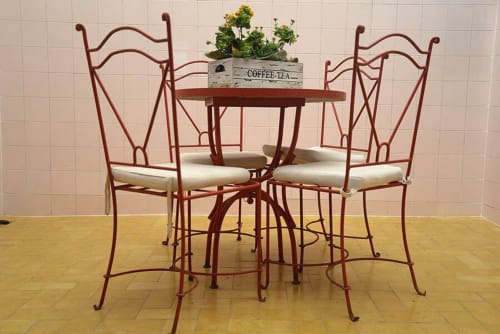 Juego de comedor de hierro forjado decorativo con sillas tapizadas en crema en el hotel Casa María de Artana